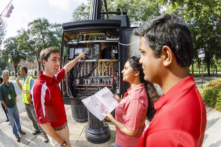 Professor and students looking into the inner workings of a traffic light.