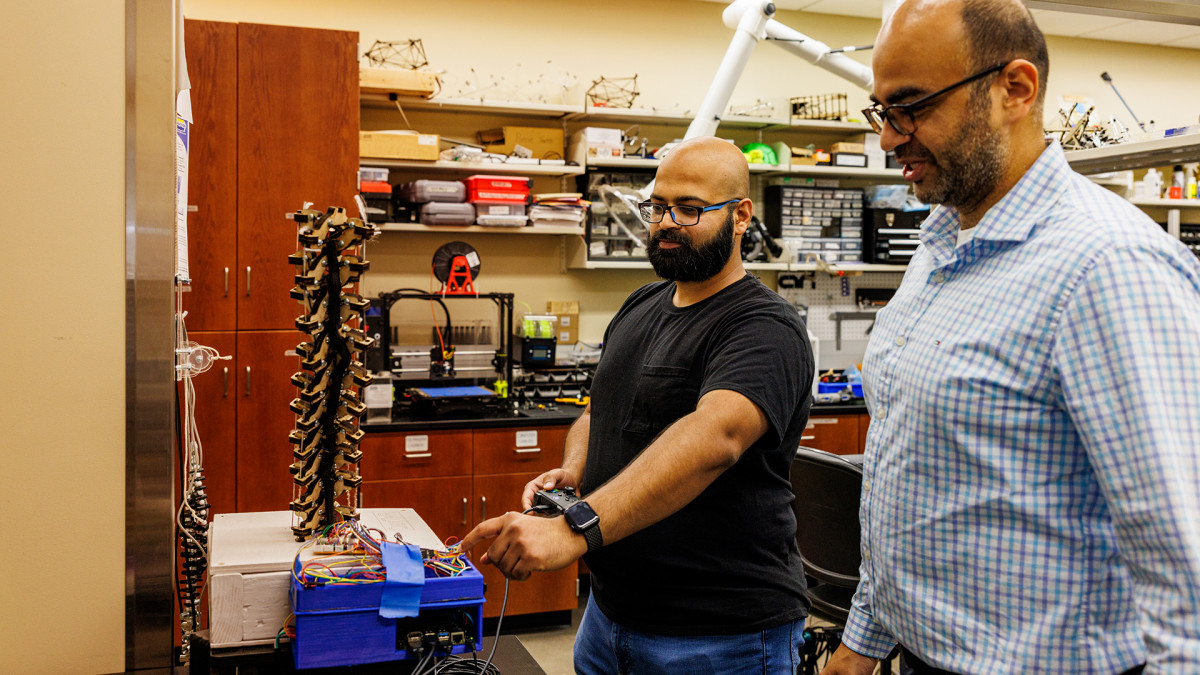 two professors working on wiring in a lab