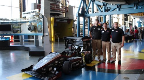 Students beside a car.
